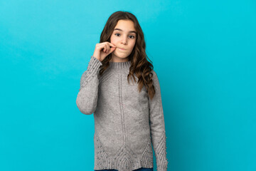 Little caucasian girl isolated on blue background showing a sign of silence gesture