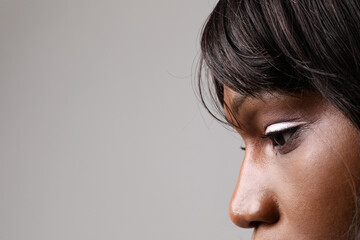 Close-up of young African American woman posing on white wall. Mindset change.