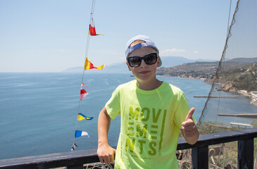 a boy stands on the deck of a ship at sea