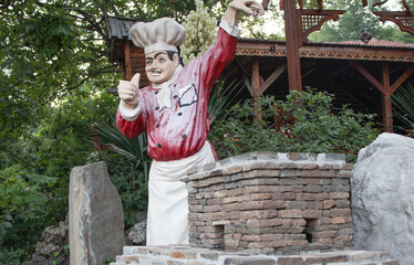 Obraz premium plaster figure of the cook at the entrance to the cafe