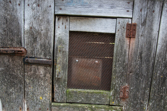 Close up of closed door on old wooden hutch for rabbits on the barnyard