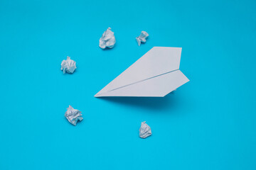 A plane made of paper on a blue background.The plane is made by hand. Origami paper.