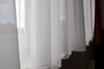 White transparent curtain closes the window, indoors. 