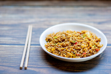 Today's dinner is fried noodles with soy sauce and eggs served on the dining table close up view..