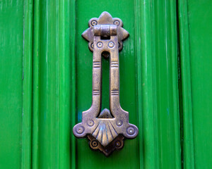 Ornate Door Knocker on a Green Door