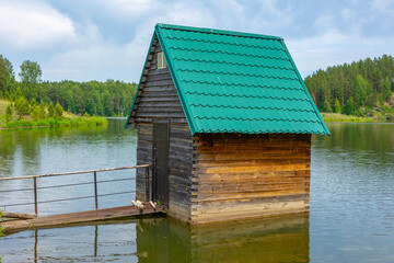 A small hut on the water near the shore of the reservoir on the Izyrak river