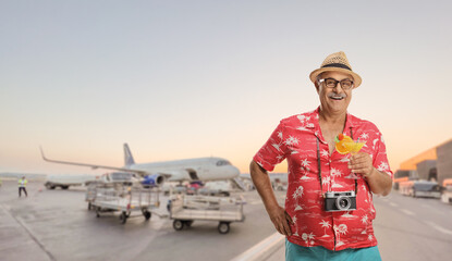 Happy mature male tourist posing on an airport