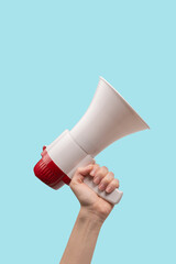Megaphone in woman hands on a white background. © Nikolay