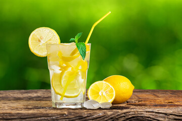 Natural lemonade with mint and fresh fruit on wooden table.
