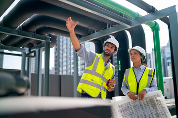 Two professional engineer discuss with blue print of construction site and stay under the floating...