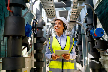 Portrait of engineer or technician worker woman stay with smiling and in area of pipe network with day light.
