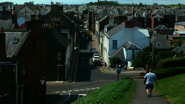 View of a small street in the city of Arbroath with pedestrians in sunny weather