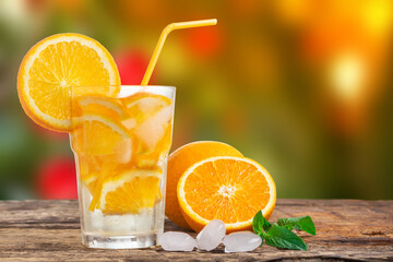 Natural lemonade with mint and fresh oranges on wooden table.