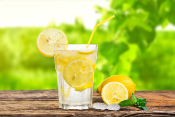 Natural lemonade with mint and fresh fruit on wooden table.