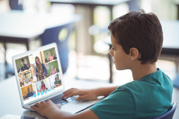 Side view of caucasian boy learning from woman teaching online over video call on laptop at home