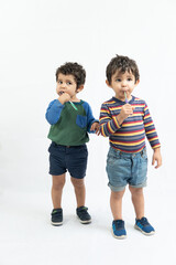 twin boys brushing their teeth on a white background