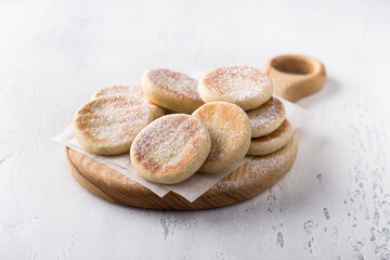 Wooden board with simple delicious homemade cookies baked in a pan on a light background