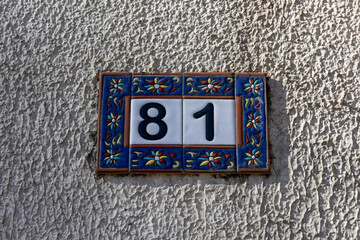 The number of the house is eighty-one 81 on the facade of the building on the street. Beautiful room on a legal basis. Blue border and white background.