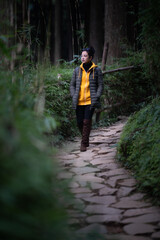 indian girl Walking in the forest in a yellow hoodie in Darjeeling in India