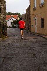 Fototapeta na wymiar A woman walking down a street in a rural village