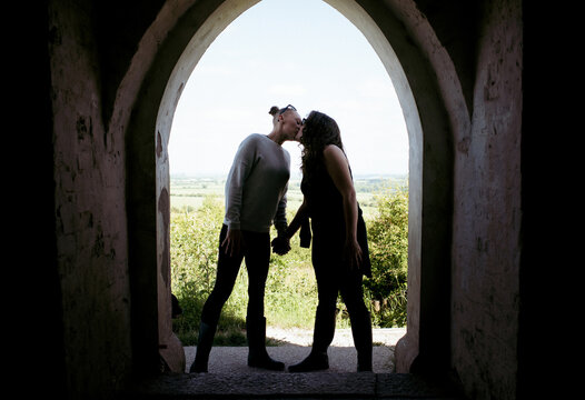 lesbian couple kissing in a beautiful stone doorway