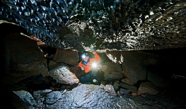 scientist exploring the Leidarendi lava cave in Iceland