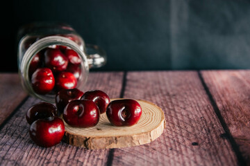 Grupo de cerezas sobre mesa de madera. 
