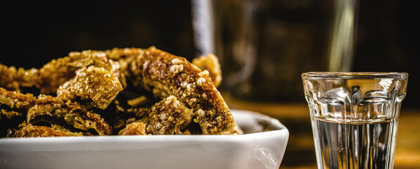 cachaça drink, Brazilian drink distilled from sugar cane, with crispy pork crackling, Brazilian...