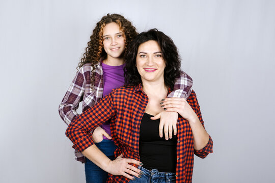 Portrait of happy mom and teeneger daughter spend time together. Teenage girl hugging her mother