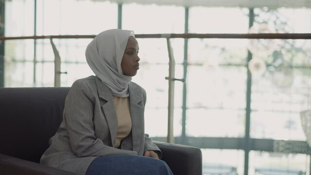 Pretty black woman in casual clothes with hijab in office