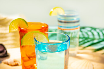 Summer non alcoholic cocktails in colorful glasses on beach with white sand. Summer sea ocean vacation and travel concept. Beach party.