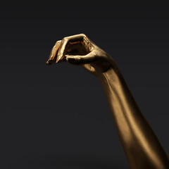 Gold painted hand holding something small object, 3d rendering female hand for advertising jewelry