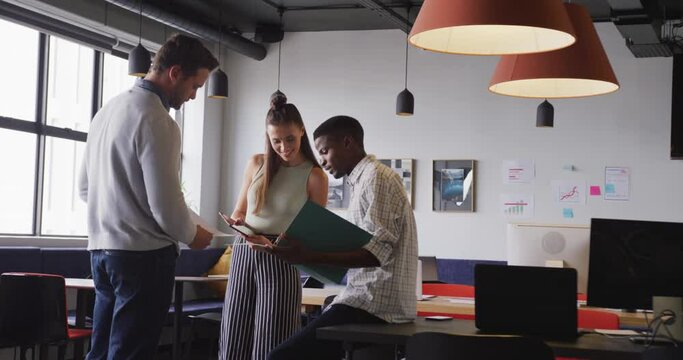 Happy diverse business people discussing work during meeting at office
