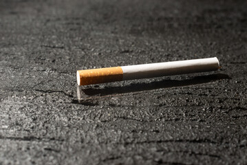 Cigarette on a dark concrete background. Smoking