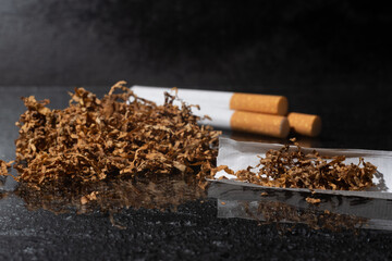 Cigarettes and tobacco against a backdrop of dark concrete