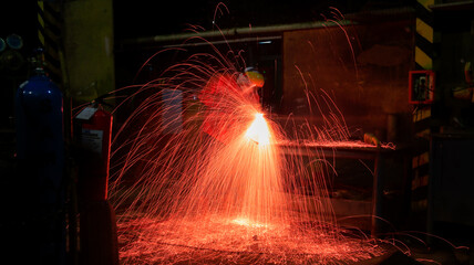 workers doing welding on steel material in assembly manufacturing workshop