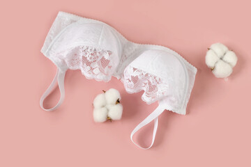 Women's white lace bra with cotton on a beige background.
