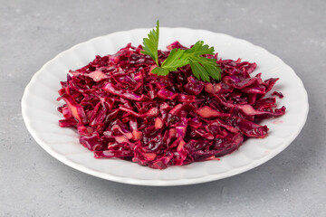 Red sauerkraut. Sour pickled cabbage on plate, red cabbage