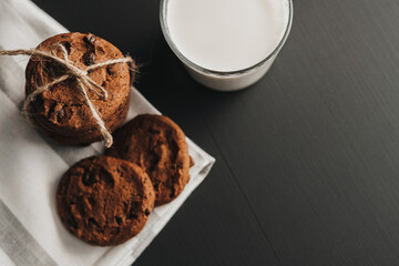 Flat Lay of Glass is Filled with Milk and Homemade Cookies on the Black Table