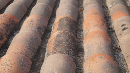 Rustic house roof. Old tiles. Weathered white wall texture. 