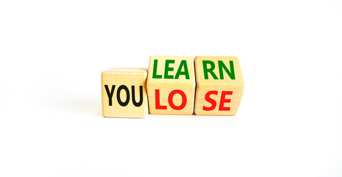 You learn or lose symbol. Concept words You learn and You lose on wooden cubes. Beautiful white table white background. Business and you learn or lose concept. Copy space.