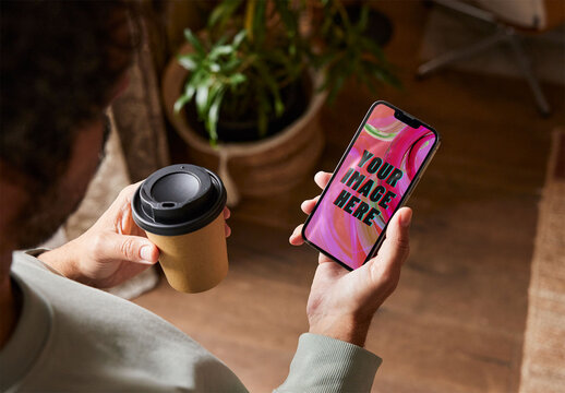 Man Holding a Smartphone Mockup with a Coffee