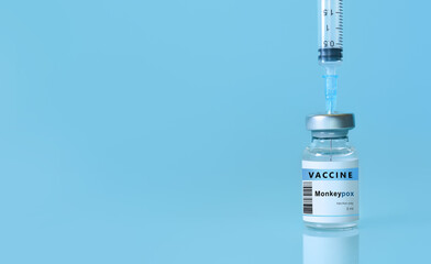 Vaccine Monkeypox and Smallpox vial with a syringe on a blue background.The concept of medicine, healthcare and science.Copy space for text. Banner