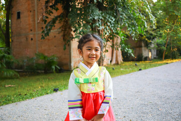 Asian children in national costumes. Lovely kid girl with Korean hanbok dress.