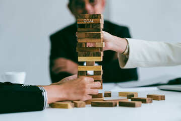 Business people playing Genga game in business strategy concept.