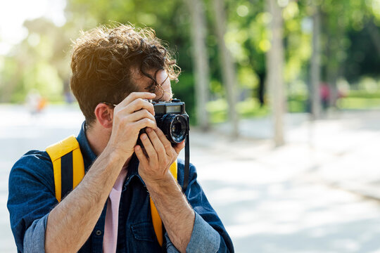 Young man taking photos in Madrid with an analog camera.
