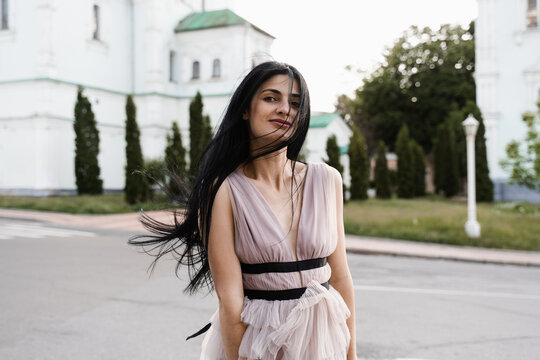 Adorable georgian woman walking in city. Attractive model in fashion dress posing on the street. Lifestyle.
