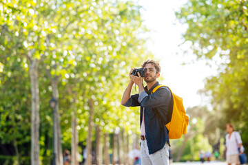 Young man taking photos in Madrid with an analog camera.