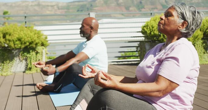 Video of relaxing senior african american couple meditating in the garden