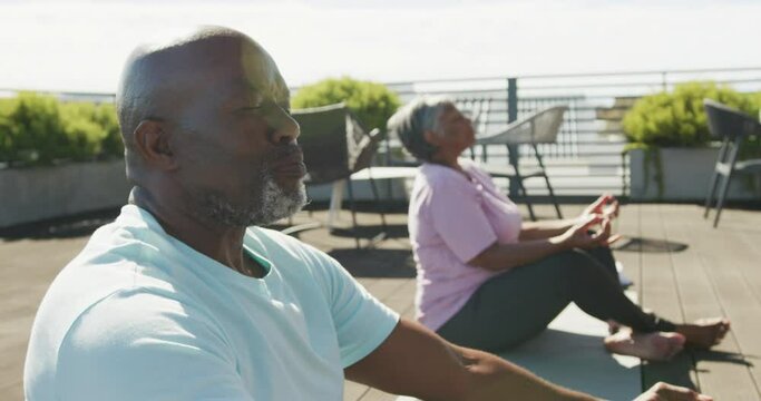 Video of relaxing senior african american couple meditating in the garden